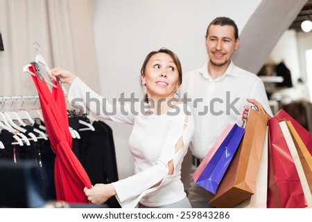 Happy couple choosing clothes at boutique