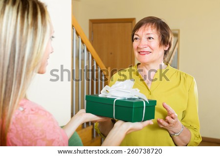 Adult daughter congratulating happy mature mother on birthday