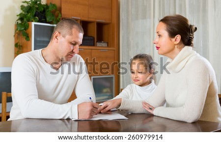 Poor family counting money to pay bills at the table at home