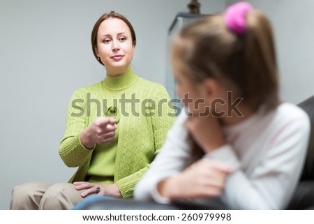 Unpleased mother scolding sad preschooler daughter at home interior