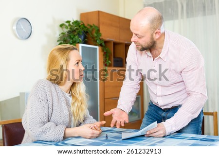 Family a wife and a husband arguing over filling in some documents and financial forms