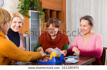 Smiling senior female friends having fun with table game indoor
