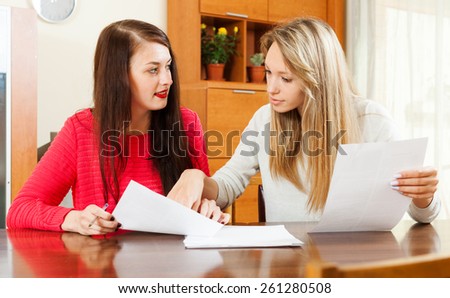 serious women looking financial documents in home or office