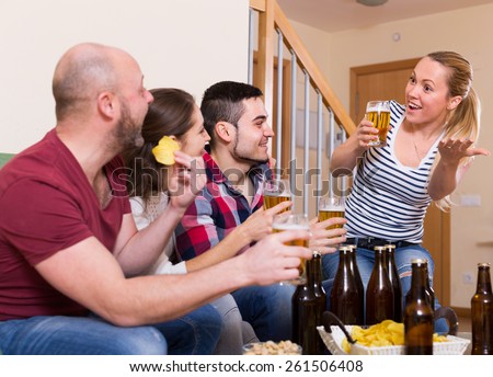 Happy people drinking beer indoor and laughing