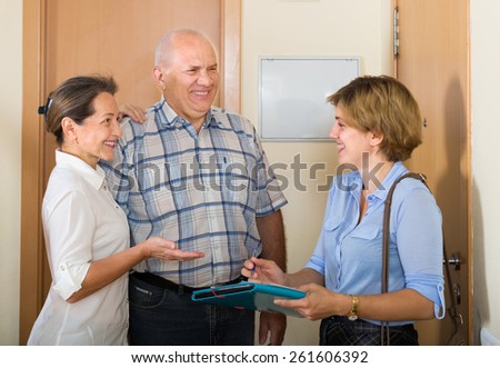 Mature couple answering the questions of young visitor  in door at home