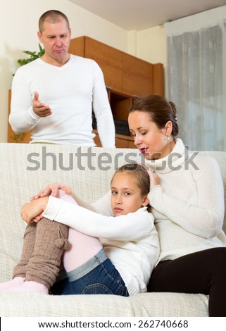 mother gives solace to crying daughter and angry father