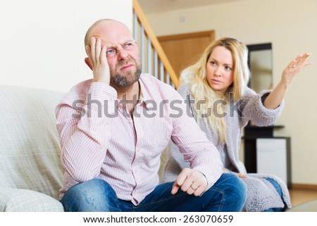 Angry guy and woman during quarrel in living room at home