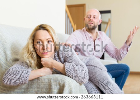 Angry man and unhappy woman having conflict at home
