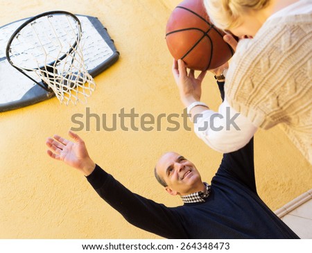 Happy spouses throwing the ball into basket