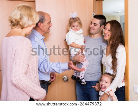Positive young family with two daughters visiting grand parents