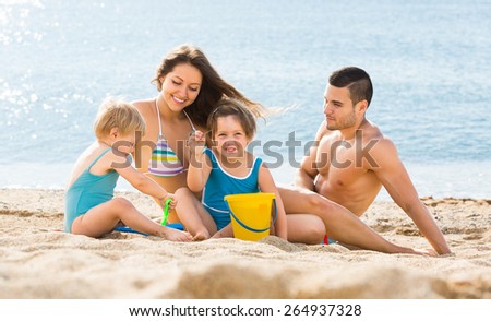 Holiday happy young family with small children on sea background