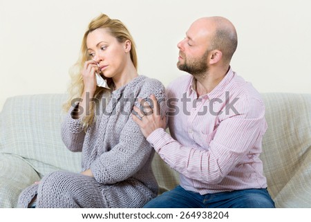 Man tries reconcile with crying woman after conflict at home. Focus on girl