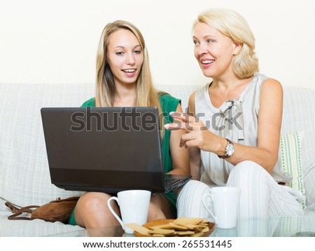 young daughter teaching mother to computer literacy