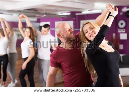 Smiling couples enjoying of partner dance indoor