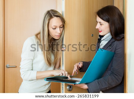 Brunette woman polling among people at home  door