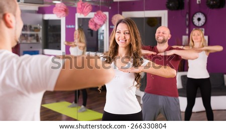 Smiling young adults having group fitness class