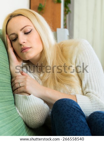 Portrait of upset blonde young woman suffering from troubles in home