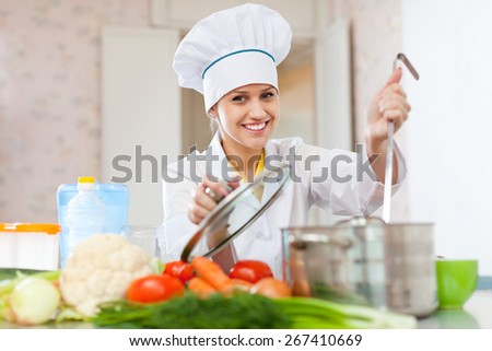 Professional cook in white hat works in the kitchen