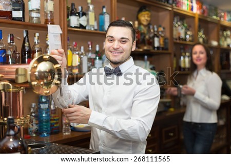 Smiling waitress and barmen working in modern bar