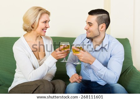 Handsome guy and mature woman drinking wine and smiling
