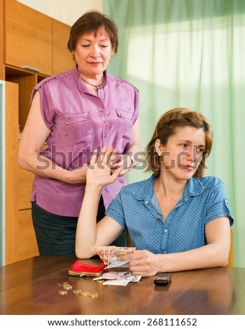 Elderly mother and her teen daughter having quarrel about financial problems