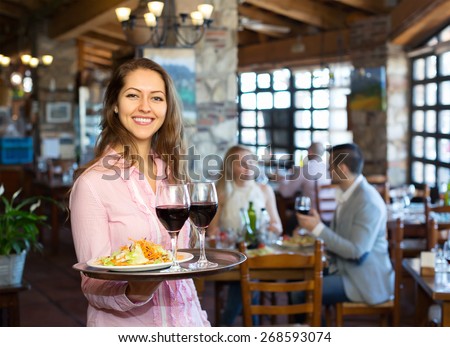 Portrait of smiling  adults having dinner and respectful waiter