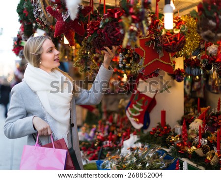 Portrait of female customer near counter with Christmas gifts and decorations