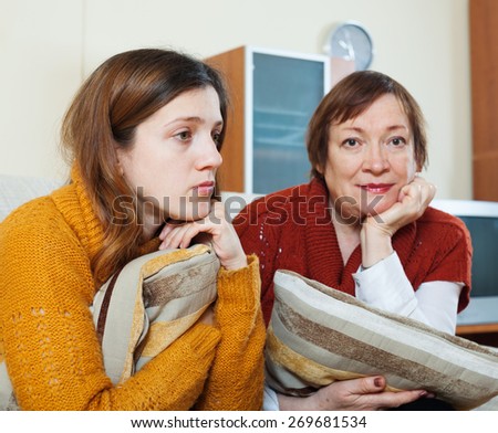 Sad mature woman and unhappy adult daughter having problems at home