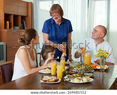 Portrait of happy three generations family posing together over healthy table at home interior