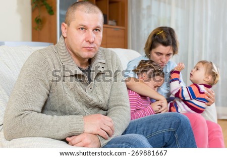 Quarell in a family. Sad husband on the front and his wife and two crying upset daughters in the back sitting on a sofa
