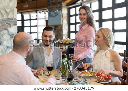 Cheerful group people having dinner at rural restaurant and drinking wine. Focus on the young man