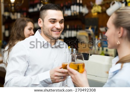 Date of smiling young couple drinking wine at counter in bar. Focus on guy
