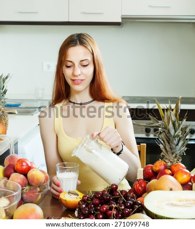 woman  drinking milk shake with fruits at home kitchen