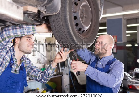 Two specialist fixing car tire leak