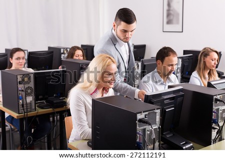 Sales department manager and employees working with computers at office. Selective focus on girl