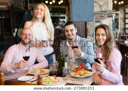 Four cheerful people sitting at restaurant table