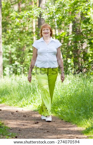 full length shot of walking mature woman  in  forest