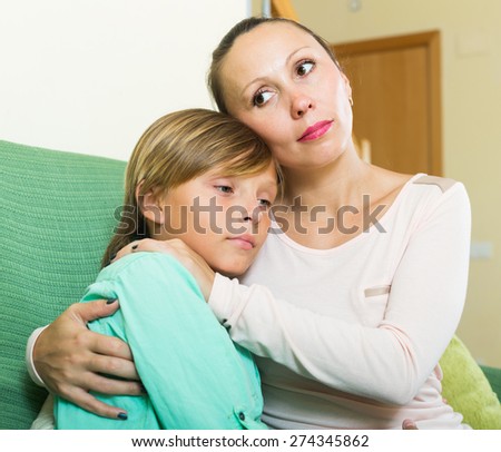 middle-aged mother consoling crying teenage son at home