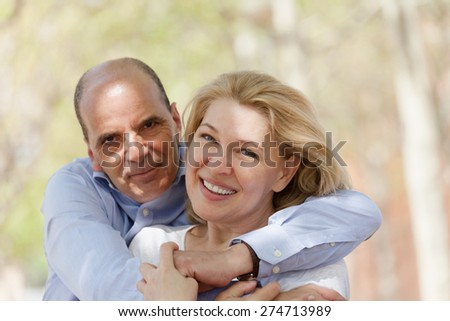 Positive portrait of mature couple at countryside in summer day