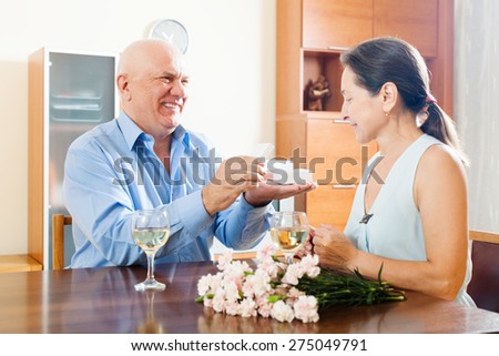 Mature man giving  woman the jewel box  at home