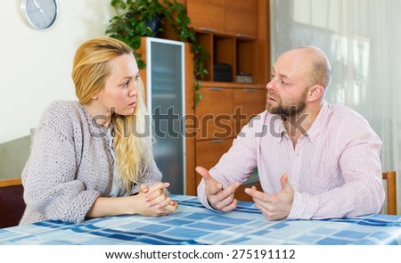 Serious  couple talking in home interior