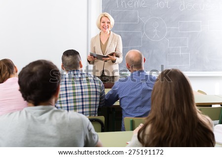 Smiling female teacher lecturing adult students in a university