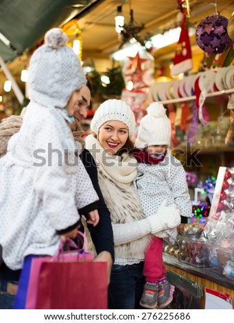 A young couple with children buying christmas decorations. Shallow focus. Focus on woman.