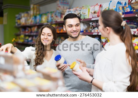 Positive people choosing tinned food at supermarket
