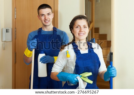 Happy cleaners cleaning room at home