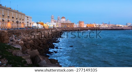 Ocean   embankment and Cathedral in twilight. Cadiz, Spain
