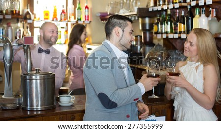 Positive happy bartender entertaining guests at a bar counter in bar
