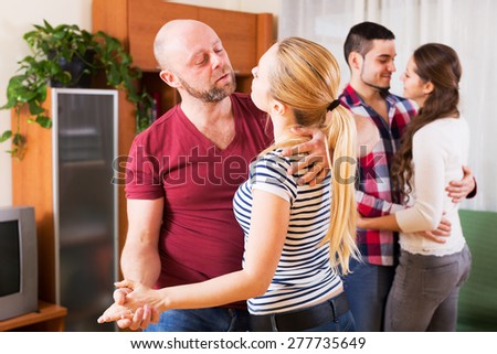 couples smiling and moving in slow dance at home
