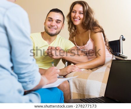 Happy couple with disabled woman talking with female agent  indoor