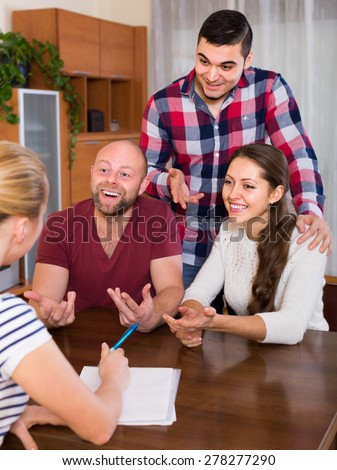 Two european couples discussing terms of insurance company and smiling